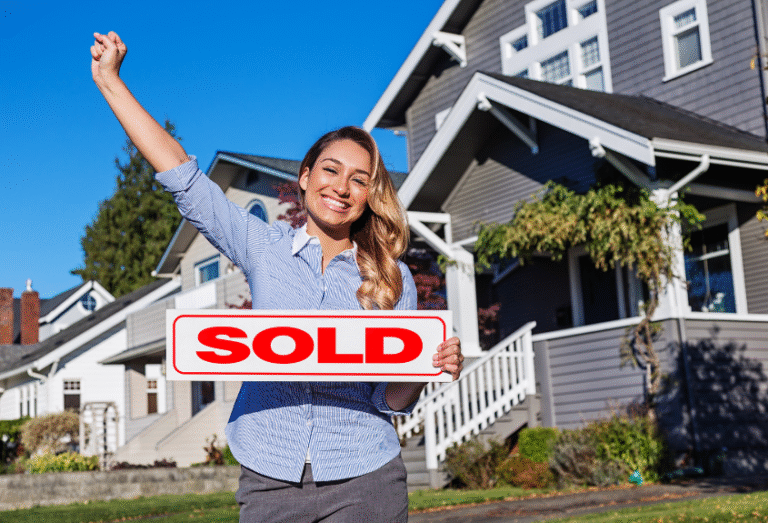 Confident realtor smiling next to a home with a bold SOLD sign, symbolizing a successful real estate transaction